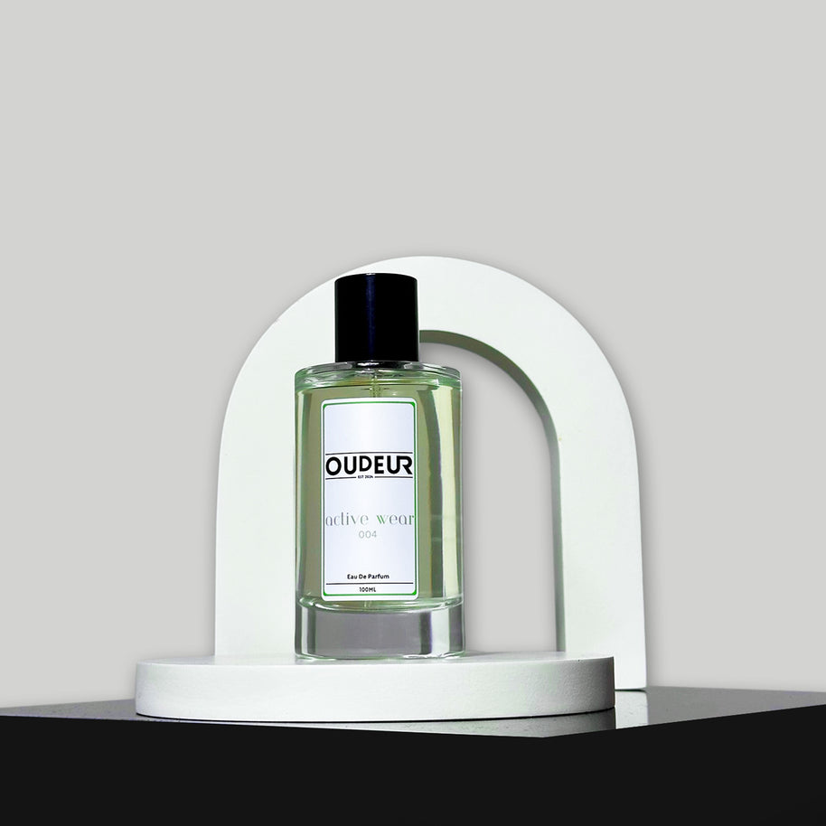 A bottle of Oudeis cologne displayed within a white, curved structure on a grey background.