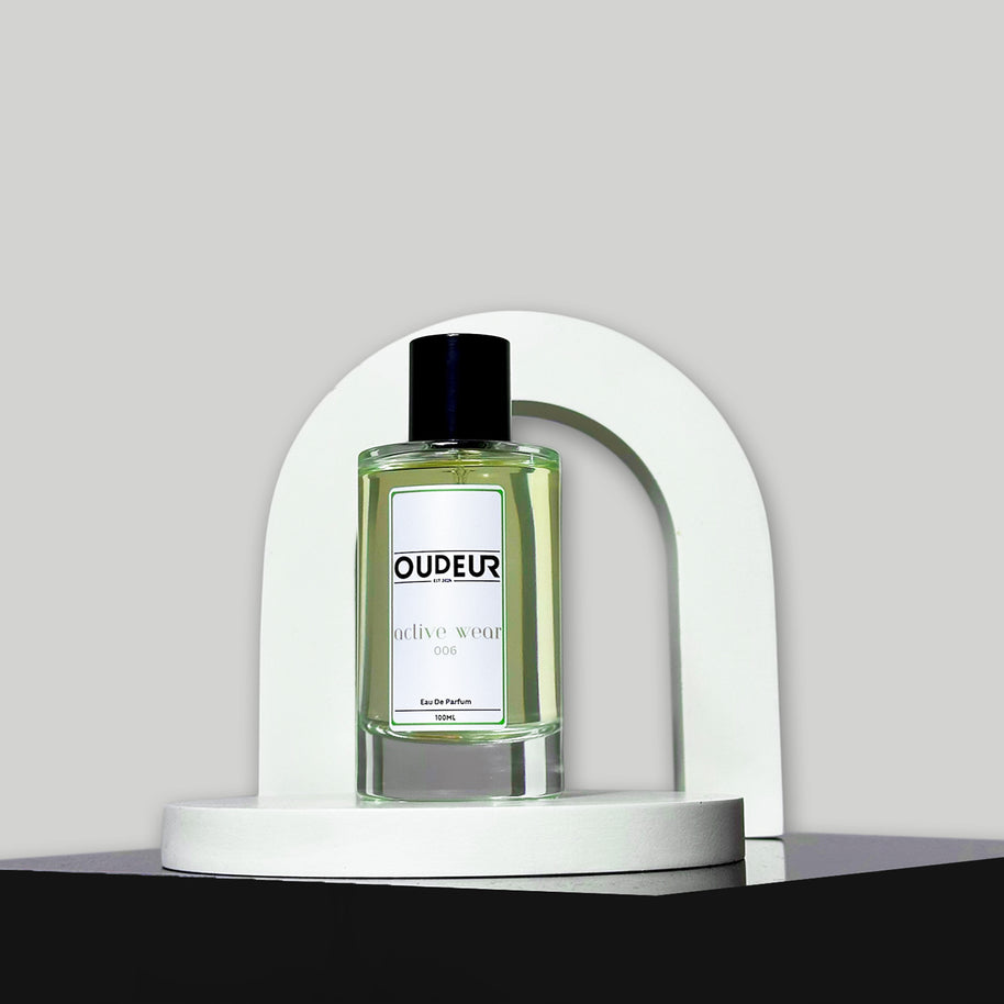 A bottle of perfume labeled 'DUPEUS' placed under a white arch on a grey background, representing the product '006 - Inspired by MFK Gentle Fluidity'.