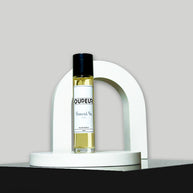 A bottle of perfume with a label that reads 'OUD EAU', placed on a white stand, with a white background.